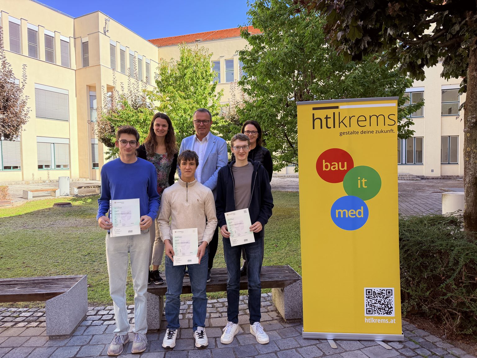 HTL Krems Absolventen mit Zeugnissen vor Schulgebäude in Krems